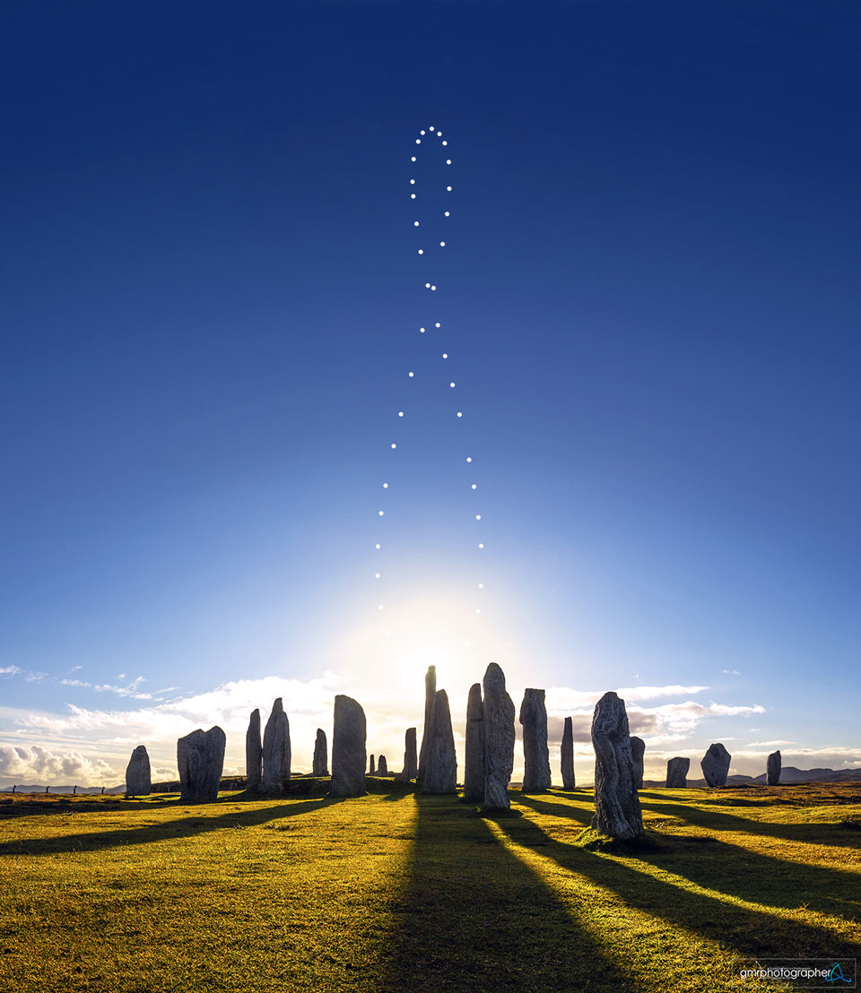 苏格兰卡拉尼什石阵上空的八字曲线（analemma）：一年中每天同一时刻拍摄的太阳合成图，太阳沿 8 字轨迹排开，前景是青铜时代立石剪影